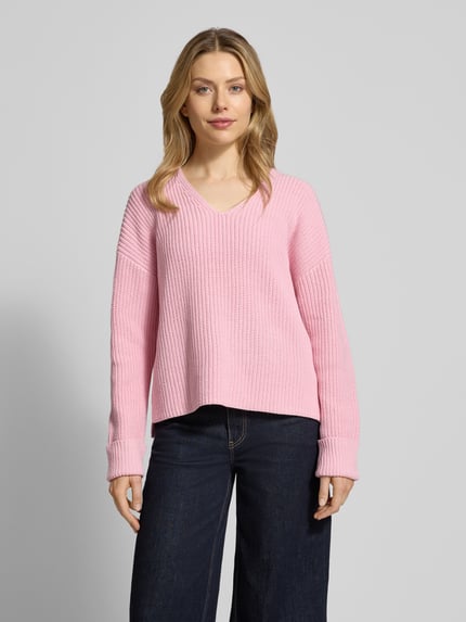 Frauenmodel trägt Oversized Strickpullover aus Baumwoll-Mix von s.Oliver RED LABEL in Rosa, V-Ausschnitt, 3/4-Arm, Rippstrick, Ganzkörperansicht von vorne.