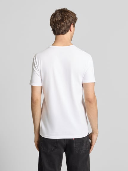 Männermodel trägt Herren T-Shirt mit Label-Detail Modell 'Foam' von Alpha Industries, Reine Baumwolle, Gerader-Schnitt, Rückenlänge 67 cm, Ganzkörperansicht Rückansicht.