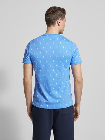 Männermodel trägt Regular Fit Pyjama-Oberteil aus reiner Baumwolle Modell 'CREW-SLEEP-TOP' von Polo Ralph Lauren Underwear mit Polo-Pony-Muster auf hellblauem Stoff, Ganzkörperansicht Rückansicht.