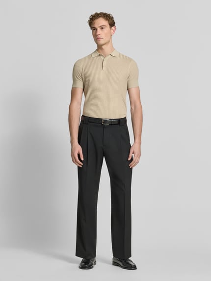 Männermodel trägt Slim Fit Poloshirt aus Viskose-Mix mit Leinen-Anteil von Antony Morato, Strick-Optik, Polokragen, beige, Ganzkörperansicht von vorne. Rückenlänge bei Größe M: 70 cm.