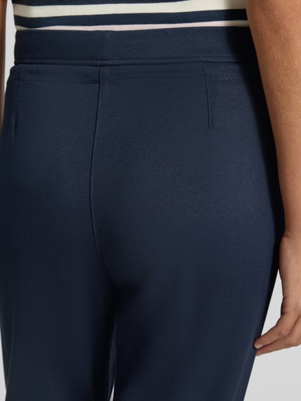 Frauenmodel trägt Hose aus Viskose-Mix mit elastischem Bund und Tunnelzug von Christian Berg Woman, dunkelblau, Nahaufnahme Rücken, Regular Fit, Stretch-Anteil, glatte Textur, elegantes Design, Bundweite 39 cm, Innenbeinlänge 68 cm bei Größe 36.