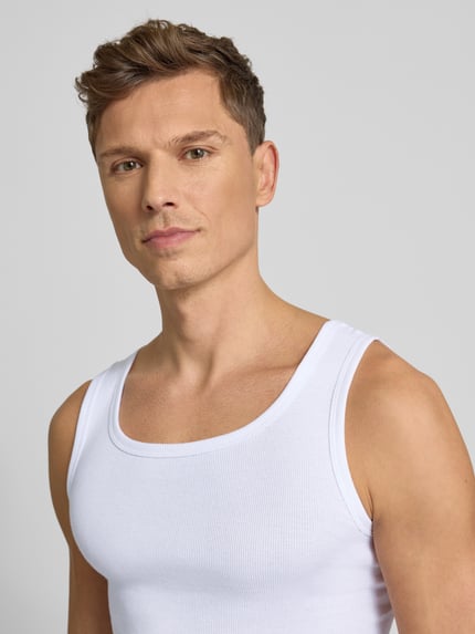 Männermodel trägt Tanktop aus reiner Baumwolle im 2er-Pack von TOM TAILOR mit feiner Rippenstruktur, Rundhalsausschnitt, schmaler Schnitt, Nahaufnahme Oberkörper.