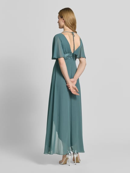 Frauenmodel trägt Midikleid aus Chiffon mit tiefem V-Ausschnitt von Jake*s Cocktail, Taillierter Schnitt, Volants, Taillenband, Ganzkörperansicht Rückansicht.