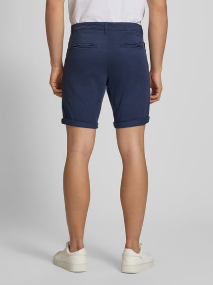 Männermodel trägt Regular Fit Shorts mit Eingrifftaschen Modell 'BOWIE' von Jack & Jones in Dunkelblau, Baumwoll-Elasthan-Mix, Ganzkörperansicht Rückansicht.