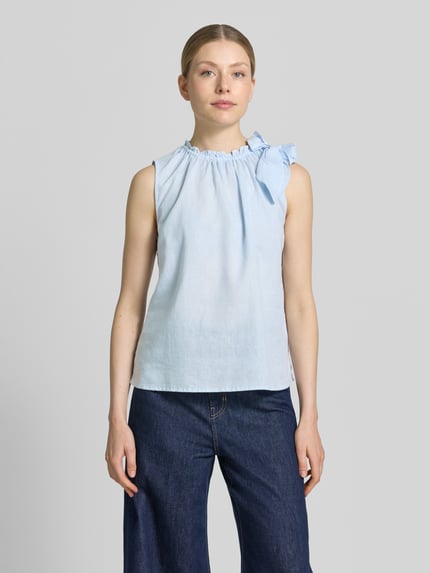 Frauenmodel trägt Regular Fit Bluse aus Viskose-Mix mit Leinen-Anteil von Christian Berg Woman in Hellblau, Zierschleife, Stehkragen mit Rüschenbesatz, Ärmelloses-Design, Rückenlänge 54 cm bei Größe 36, Ganzkörperansicht von vorne.