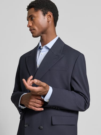 Männermodel trägt dunkelblaues Relaxed Fit Sakko mit Viskose-Anteil Modell 'RELAXED-LIAM' von Selected, feine Struktur, Nahaufnahme Oberkörper.