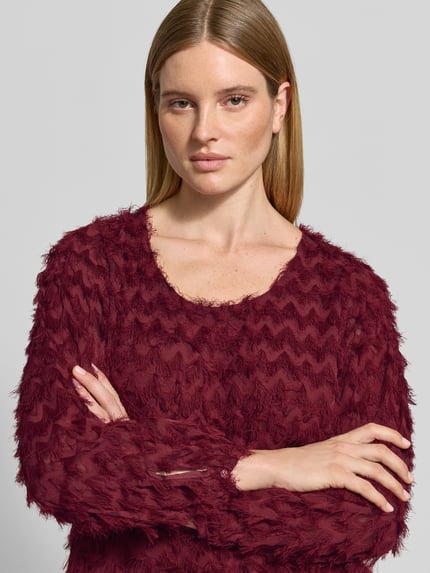 Frauenmodel trägt Blusentop mit strukturierter Chiffonoberfläche von Selected, unifarben, langarm, Rundhals, Nahaufnahme Oberkörper.