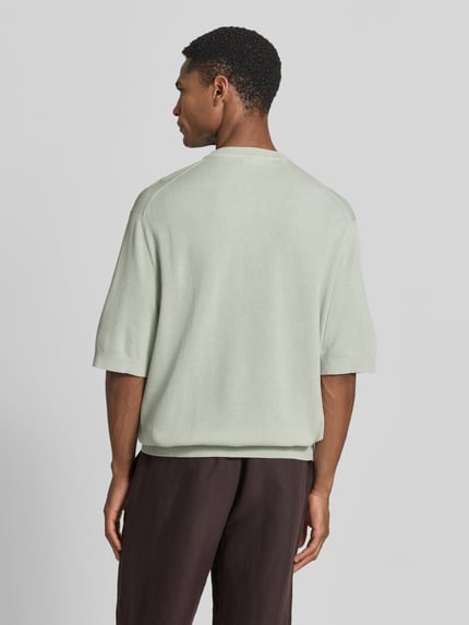 Männermodel trägt Relaxed Fit T-Shirt aus reiner Baumwolle Modell 'TORINO' von SELECTED HOME in Strickoptik, Ganzkörperansicht Rückansicht.