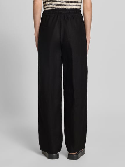 Vrouwenmodel draagt Regular Fit wijdte broek uit puur linnen model 'FARINA' van Brax, look: effen, boord elastisch met tunnelkoord, steekzak, materiaal: linnen, geheel lichaam achteraanzicht.