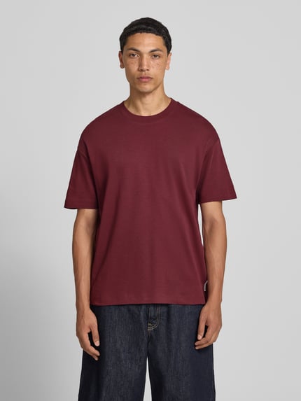 Männermodel trägt Relaxed Fit T-Shirt aus reiner Baumwolle von Marc O'Polo Denim in Dunkelrot, schlichte Optik, Ganzkörperansicht von vorne. Herren T-Shirt.