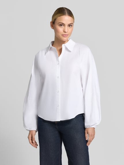 Kobieta prezentuje bluzkę koszulową Regular Fit z bufiastymi rękawami Model 'Sunna' od My Essential Wardrobe, biała, widok z przodu, krój regular fit, kołnierzyk koszulowy, z długim rękawem, listwa guzikowa, długość tyłu w rozmiarze 36: 67 cm, długość rękawów w rozmiarze 36: 63 cm, faktura gładka