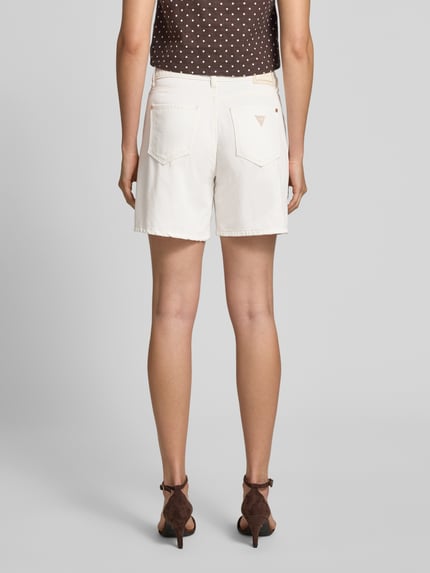 Frauenmodel trägt Wide Fit Shorts mit Lyocell-Anteil in Denim-Optik von Guess im 5-Pocket-Design, cremeweiß, Baumwoll-Lyocell-Mix, Ganzkörperansicht Rückansicht.