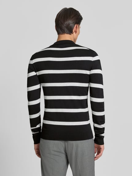 Männermodel trägt Strickpullover mit Polokragen Modell 'VERO' von MCNEAL, schwarz-weiß gestreift, Viskose-Mix, Ganzkörperansicht Rückansicht.