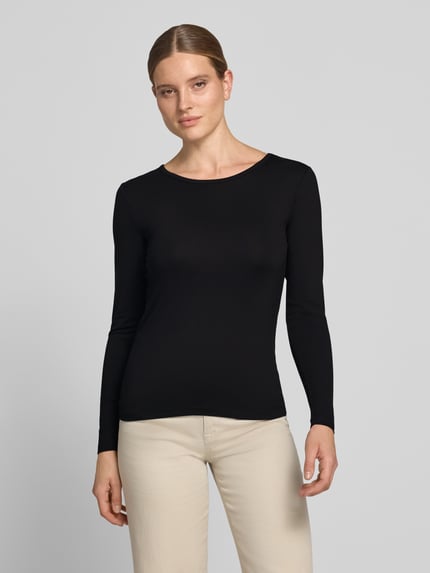 Vrouwenmodel draagt zwart shirt met lange mouwen van mix van viscose en elastaan, slim fit, Model 'Liana' van FREE/QUENT, ronde hals, ruglengte maat S 59 cm, volledig lichaam vooraanzicht.