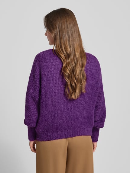 Frauenmodel trägt Oversized Strickpullover mit Rundhalsausschnitt Modell 'Isolde' von LOLLYS LAUNDRY in Lila, Material-Mix mit Mohair-Anteil, gerippte Abschlüsse, Ganzkörperansicht Rückansicht.