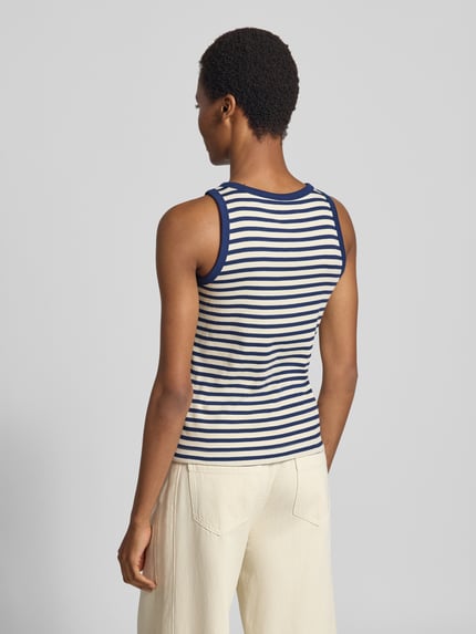 Vrouwenmodel draagt Slim Fit Tanktop uit katoenmix van s.Oliver RED LABEL in blauw-wit gestreept, crèmekleurige broek, volledige achteraanzicht