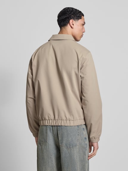 Mannelijk model draagt Jacke mit Zweiwege-Reißverschluss Modell 'CATSKILLS' van Jack & Jones in regular fit, beige kleur, met omgeslagen kraag, label-stitching en zichtbare tweerichtingsrits, ruglengte 64 cm, schouderbreedte 49 cm, borstwijdte 59 cm, mouwlengte 66 cm, volledig zicht van achteren.