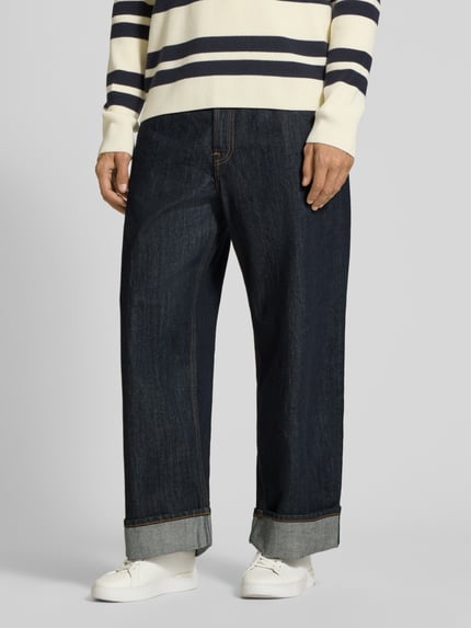 Männermodel trägt Wide Fit Jeans aus reiner Baumwolle Modell 'TIMOTHY' von Samsøe Samsøe, dunkelblau, 5-Pocket, Nahaufnahme Unterkörper.