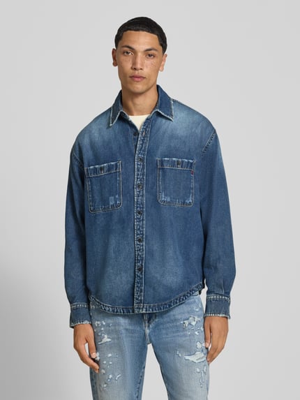 Męski model nosi Regular Fit Jeanshemd mit Viskose-Anteil od Replay, mieszanka bawełny z dodatkiem wiskozy, kołnierzyk typu kent, kieszenie na piersi, niebieski, długi rękaw, listwa guzikowa, Ganzkörperansicht von vorne.