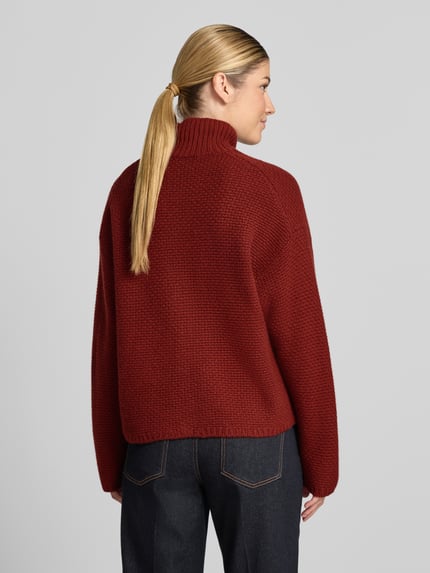 Vrouwenmodel draagt Strickpullover aus Kaschmir mit Stehkragen van windsor. in rood, relaxed fit, structuurpatroon, pure kasjmier, lange mouw, detailbeschrijving: rugaanzicht, lengte rug 63 cm, mouwlengte 58 cm.