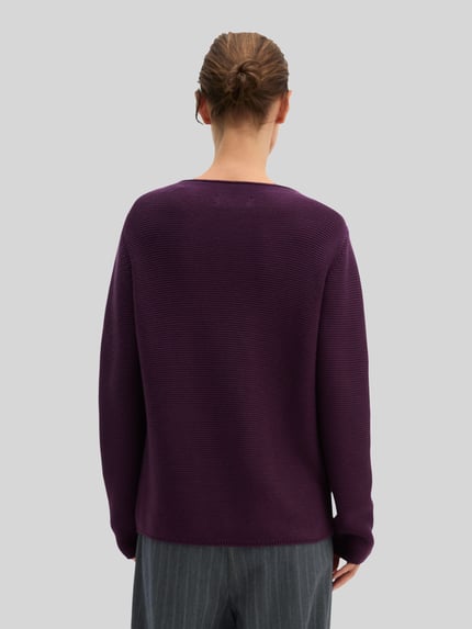 Frauenmodel trägt Regular Fit Pullover aus reiner Baumwolle von MARC O'POLO in unifarbener, violetter Strickoptik, Ganzkörperansicht Rückansicht.
