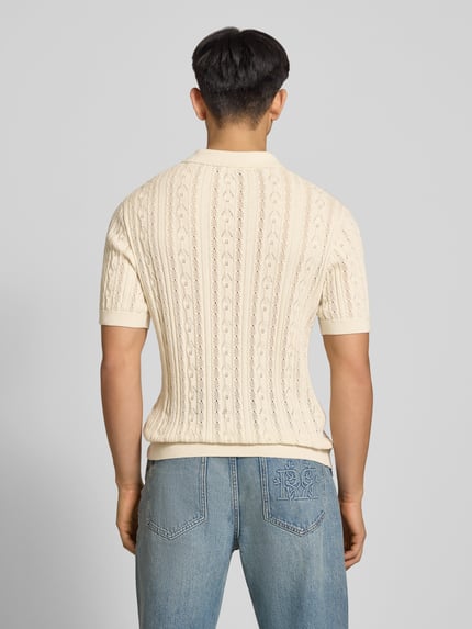 Männermodel trägt Slim Fit Strick-Poloshirt mit Label-Stitching von REVIEW, Zopfmuster, Reine Baumwolle, Rückenlänge 69 cm, Ganzkörperansicht Rückansicht.