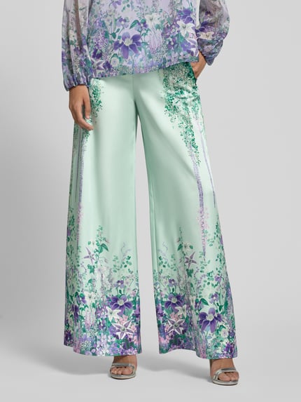 Frauenmodel trägt Hose aus Satin mit weitem Bein von Marc Cain im Allover-Look, seitlicher Reißverschluss, zarte Farben, Nahaufnahme Oberkörper