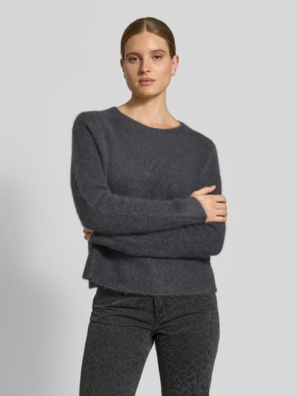 Frauenmodel trägt Wollpullover aus Alpaka-Woll-Mix von Juvia, lockere Passform, meliertes Dunkelgrau, Strick-Optik, Nahaufnahme Oberkörper.