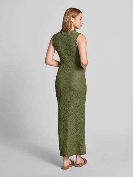 Frauenmodel trägt Maxikleid mit Rundhalsausschnitt Modell 'FALL' von Vila in Olivgrün, Material-Mix mit Stretch-Anteil, gerader Schnitt, Rückenlänge bei Größe S 136 cm, Brustweite bei Größe S 33 cm, Ganzkörperansicht Rückansicht.