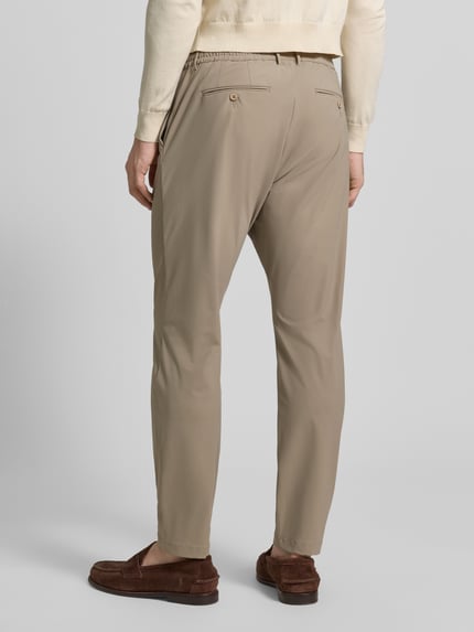 Männermodel trägt Slim Fit Hose mit Paspeltaschen am Gesäß von CRUNA, Material-Mix mit Stretch-Anteil, Eingrifftaschen, Ganzkörperansicht Rückansicht