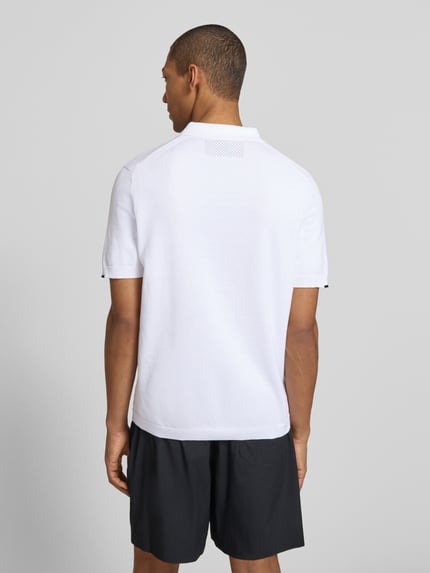 Männermodel trägt Regular Fit Poloshirt aus reiner Baumwolle Modell 'KN_EVER-X' von BOSS Green, unifarben weiß, Feinstrick, Ganzkörperansicht Rückansicht.