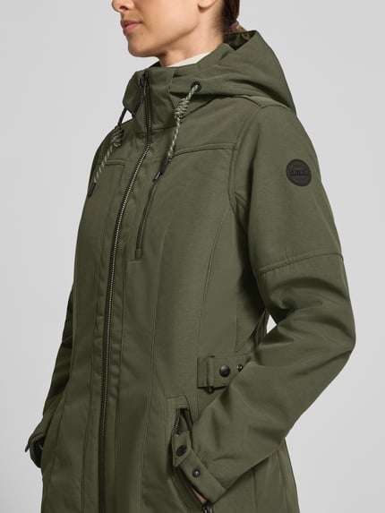 Kobieta nosi zieloną Jacke mit Ärmelriegeln Modell 'GW61' od G.I.G.A. DX, krój regular fit, kurtka z kapturem, zamek dwukierunkowy, kieszenie na zamek, długość pleców w rozmiarze 36: 83 cm, szerokość ramion w rozmiarze 36: 38 cm, szerokość klatki piersiowej w rozmiarze 36: 52 cm, długość rękawa w rozmiarze 36: 61 cm, tekstura gładka, zbliżenie na górną część ciała z przodu