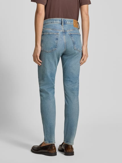 Kobiece modelka nosi Skinny Fit Jeans mit Eingrifftaschen od Polo Ralph Lauren, mieszanka bawełny i elastanu, efekt znoszenia, wpuszczane kieszenie, niebieski odcień, prosty krój, widok całej sylwetki z tyłu.