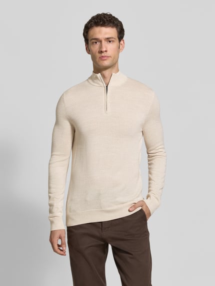 Männermodel trägt Slim Fit Strickpullover aus Woll-Mix mit Troyer-Kragen von Christian Berg Men, beige, elastische Abschlüsse, Ganzkörperansicht von vorne.