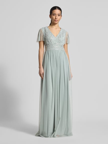 Frauenmodel trägt Regular Fit Abendkleid mit floralem Ziersteinbesatz von Christian Berg Cocktail in Semitransparent, V-Ausschnitt, Kurzärmelig, blickdichter Unterrock, Rückenlänge 156 cm, Brustweite 40 cm, Ärmellänge 22 cm, Ganzkörperansicht von vorne.