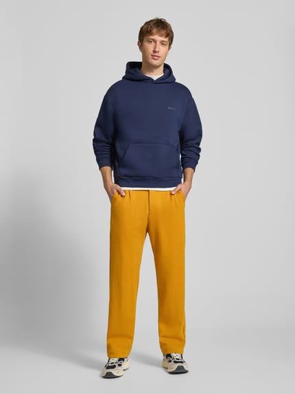 Männermodel trägt Straight Fit Chino mit Gesäßtaschen Modell 'SAMUEL' von CHILL PILL in Gelb, Baumwoll-Mix, Ganzkörperansicht von vorne.