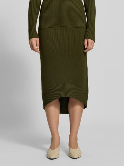 Frauenmodel trägt Midirock aus Woll-Mix von Victoria Beckham in Olivgrün mit Ripp-Struktur, gerader Schnitt, elastischer Bund, Nahaufnahme Unterkörper.