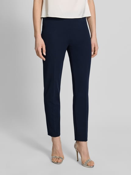 Vrouwenmodel draagt Hose mit Bügelfalten van Vera Mont in donkerblauw, materiaalmix met stretch, regular fit, persplooien, elastische band, bandwijdte maat 36: 38 cm, binnenbeenlengte maat 36: 77 cm. Volledige lichaamsaanzicht van voren.