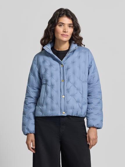 Frauenmodel trägt Regular Fit Daunenjacke mit Logo-Stitching von Tommy Hilfiger in Hellblau mit goldenen Knöpfen, Damen Daunenjacke, Nahaufnahme Oberkörper.