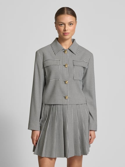 Vrouwenmodel draagt Boxy Fit Kurzblazer met Vichy-Muster Modell 'ALERO-2' van HUGO, zwart-wit geruit, borstzakken, lange mouwen, eenrijige knopen, Ganzkörperansicht van voren.