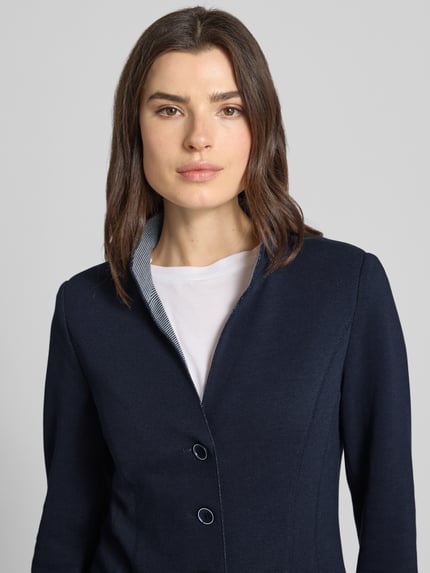 Frauenmodel trägt Blazer mit Stehkragen und Eingrifftaschen von WHITE LABEL aus Baumwoll-Mix, taillierter Schnitt, Nahaufnahme Oberkörper.