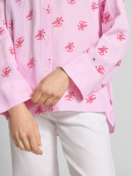 Frauenmodel trägt Oversized Hemdbluse aus Leinen-Viskose-Mix von Tommy Hilfiger, Optik:Allover-Muster, Muster: Gestreift, Applikation: Logo-Stitching, Knopfleiste, Langarm, Manschette, abgerundet, asymmetrisch, Ganzkörperansicht von vorne.