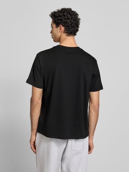 Męskimodel nosi T-Shirt mit Rundhalsausschnitt im 2er-Pack von CHAMPION, czarny, bawełna, krój regular fit, detal z logo, długość tyłu 69 cm, Ganzkörperansicht Rückansicht.