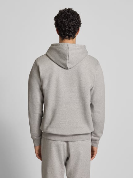Männermodel trägt Hoodie mit Kapuze von adidas Originals aus Baumwoll-Mix, Lockerer-Schnitt, Kapuze, Känguru-Tasche, Rückansicht, Ganzkörperansicht Rückansicht.