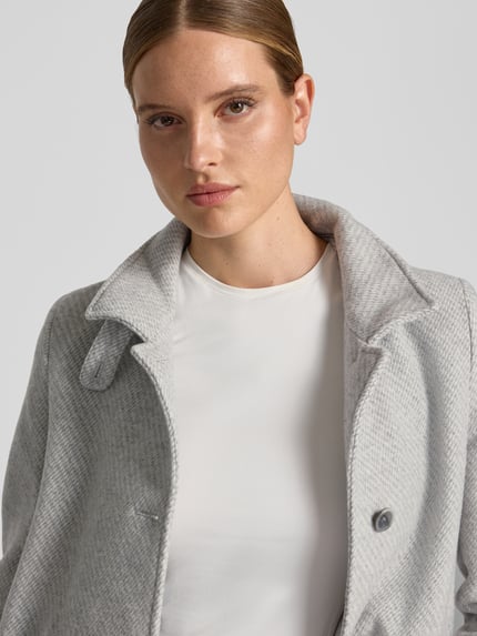 Frauenmodel trägt Mantel aus Woll-Mix mit Stehkragen Modell 'ASTOR' von CINQUE, Hellgrau, strukturierte Oberfläche, Nahaufnahme Oberkörper. Damen Mantel, gerader Schnitt, Knopfleiste, aufgesetzte Taschen, Rückenlänge 90 cm, Schulterbreite 36 cm, Brustweite 45 cm, Ärmellänge 62 cm.