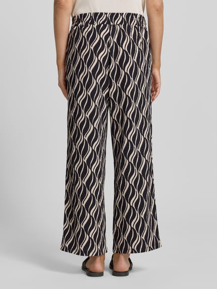 Frauenmodel trägt Culotte mit Allover-Muster und elastischem Bund von Betty Barclay, Material-Mix mit Stretch-Anteil, Loose-Fit, Bundweite 38 cm, Innenbeinlänge 68 cm, Rückansicht Ganzkörperansicht.