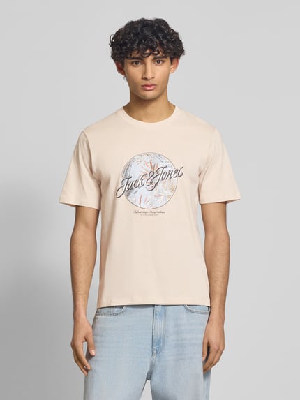 Męski model nosi t-shirt z nadrukiem, okrągły dekolt, bawełna, krój regular fit, model 'HONOLULU' od Jack & Jones, długość tyłu 68 cm, przód ujęcie całej sylwetki.
