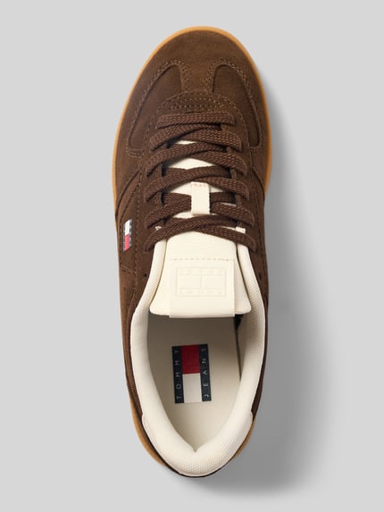 Produktfoto, Low Top Sneaker in Wildleder-Optik von Tommy Jeans, brauner Damen Sneaker mit Label-Print, abgerundete Schuhspitze, flache Absatzform, Schnürung, weiße und braune Farbakzente, strukturierte Oberfläche.