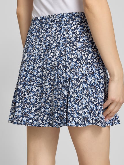 Vrouwenmodel draagt Mini-Skort uit pure viscose model 'NALA LIFE' van Only, all-over bloemenprint, licht uitlopend, elastische tailleband, mini-lengte, detailopname heupen en rok.