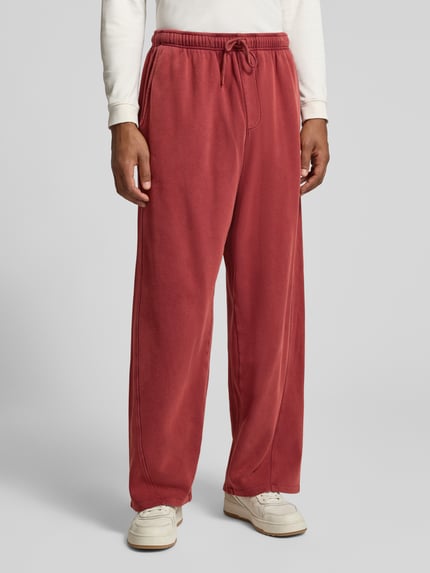 Männermodel trägt Sweatpants mit elastischem Bund Modell 'JITBAY' von American Vintage in Rot, reine Baumwolle, Relaxed Fit, Nahaufnahme Oberkörper.